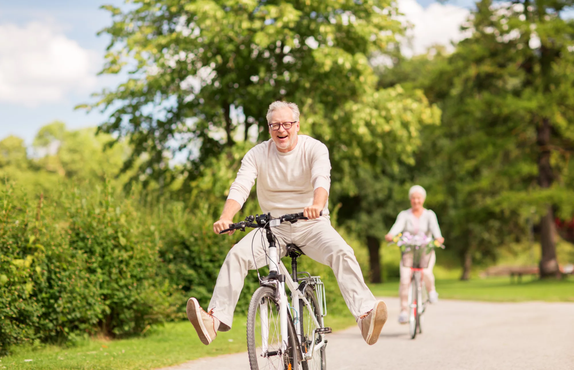 two elderly people riding bikes, having fun