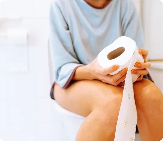 a woman holding a roll of toilet paper