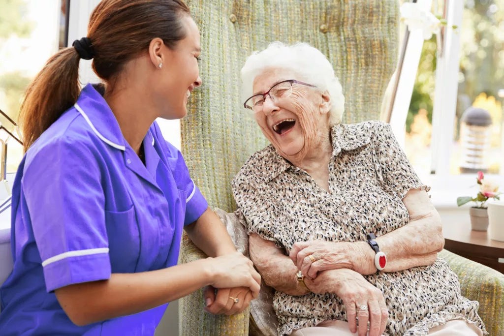 elderly women and nurse laughing together